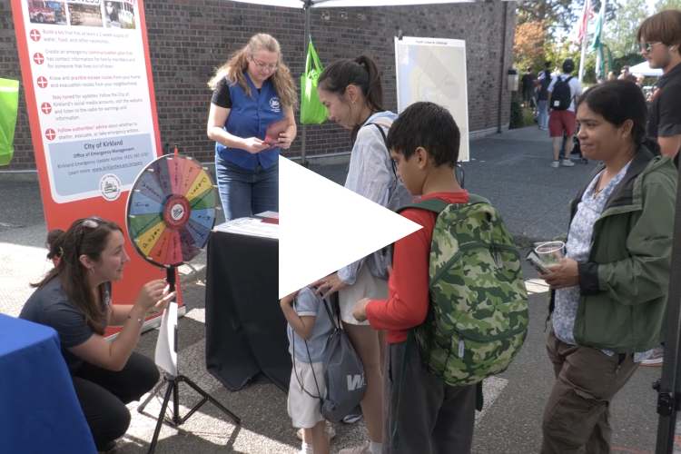 City Hall for All video thumbnail showing a play button over a still image of community members at a City booth