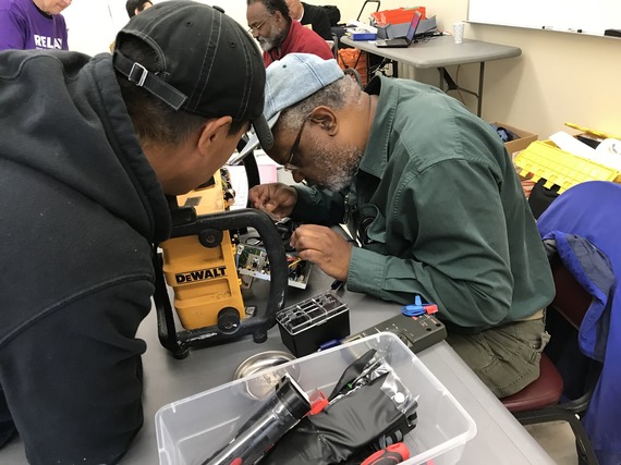 Two people fixing an item.