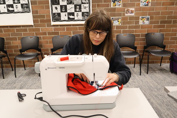A volunteer mending clothing.