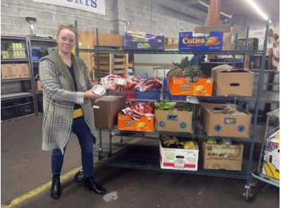 Rachael Beason standing next to surplus food.