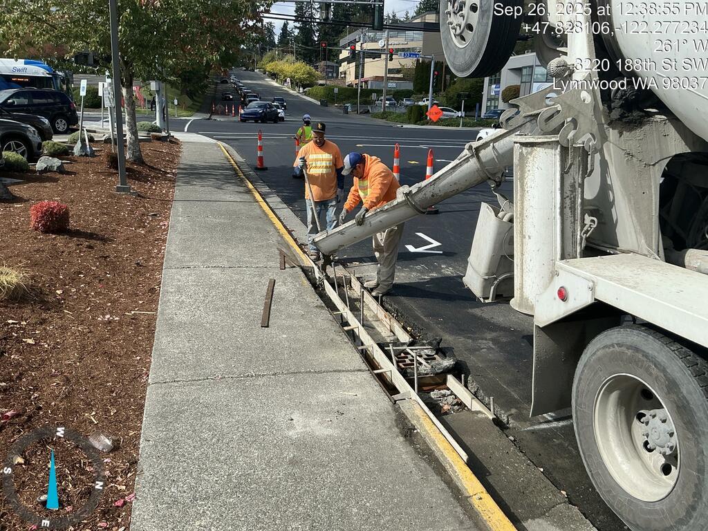 Crews pouring concrete curb and gutter.