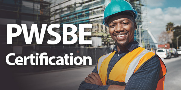 African American man wearing a hard hat and safety vest smiling and standing in front of a construction site with the words PWSBE Certification