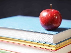 Books stacked with an apple on top