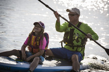 Two people sitting on stand up paddleboard