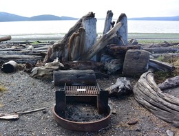 Burn ban reminder on cooking grill with beach in the background. Spencer Spit State Park.