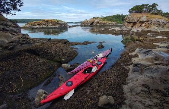 Kayaks rest in a beach cove at Sucia Island.