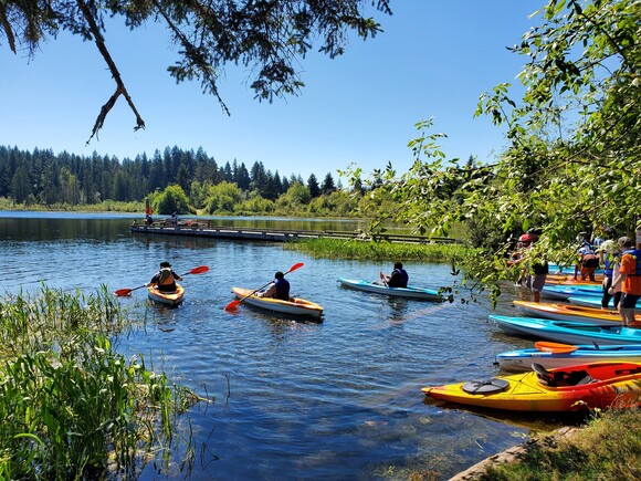 Kayakers launching at beautiful forest lake