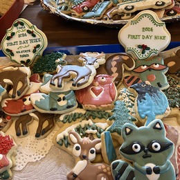 A plate of decorated cookies includes a welcome to First Day Hikes 2024