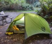 A green tent with bedding inside set up at one of our campsites