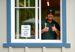 A park aide gives the thumbs-up from within their booth at a park welcome station
