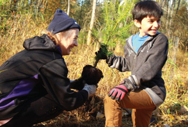 Two volunteers planting small tree