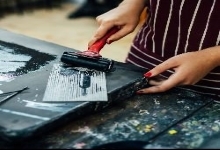 Person rolling ink for print making