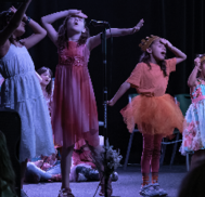 Students singing and dancing on a stage