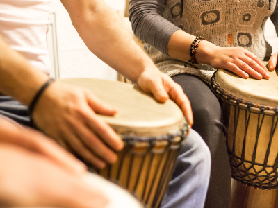 Hand drums being playing in a small group