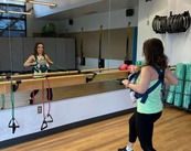 workout instructor wearing a front-facing baby harness