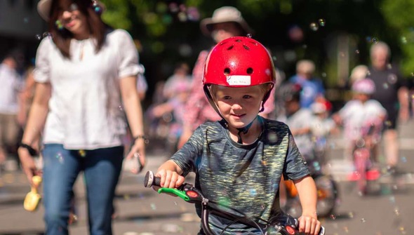 Child riding his bicycle surrounded by bubbles