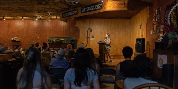 poet reading to an audience at a cafe