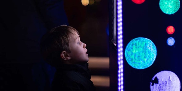 Young child looking at an illuminated art display