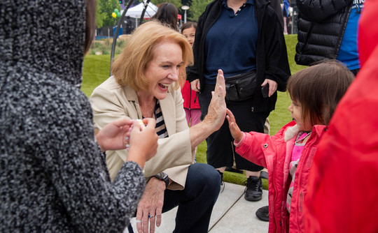 Mayor Jenny Durkan high-fives a young girl at Yesler Terrace Park