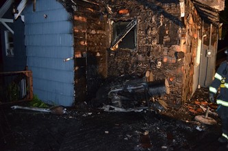 Exterior of a home that's been charred resulting from a grill fire