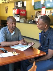 OLS Engagement Specialist Ahmed Abdi with Farah Ismail, owner of the Banana Grill Restaurant in South Seattle.