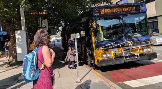 Photo of a woman waiting for the E line bus in downtown Seattle