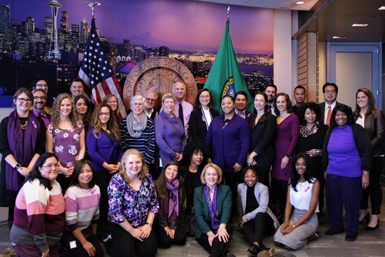 Mayor Jenny Durkan poses with staff from the Mayor's Office and Human Services Department to recognize Purple Thursday