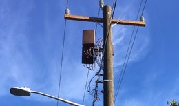 Small wireless equipment side mounted on a wood utility pole.