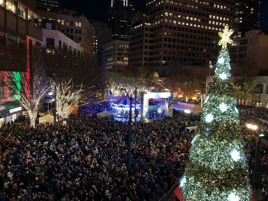 Photo of the Downtown Seattle Tree Lighting from above showing a large crowd gathered around the tree