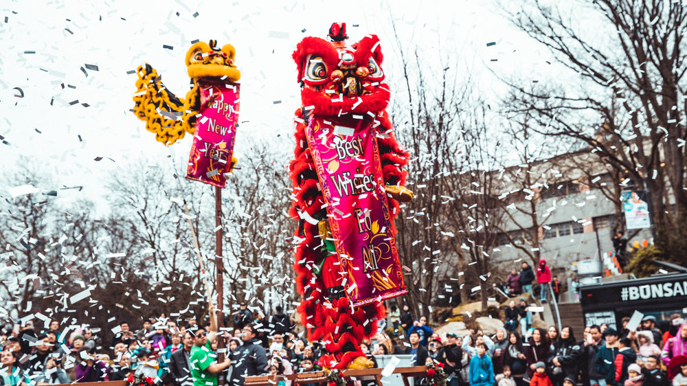 A photo of a lunar new year celebration featuring red and yellow lion dancers