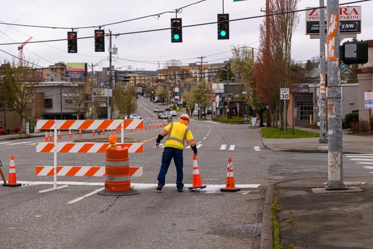 An SDOT worker moves traffic cones on a closed street