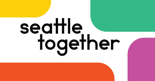 "Seattle together" written in a sans-serif font with multicolor shapes in the corners