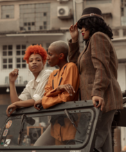 Three Black people riding in a jeep