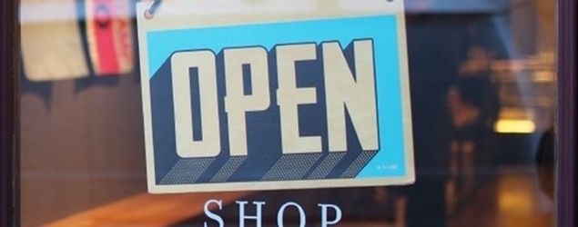 Photo of an "open for business" sign in a store window