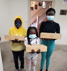 people of color holding boxes with laptops