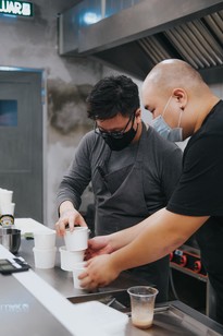 Two restaurant workers preparing food for take out
