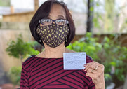 An older Seattle resident poses with her vaccination card after receiving the COVID-19 vaccine from Seattle Fire