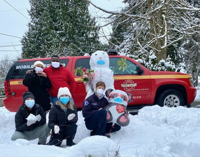 Members of the Seattle Fire Department deliver COVID-19 vaccinations, in the snow, on Valentine's Day