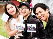 Youth smiling and waving paper flags with SYEP logo on them