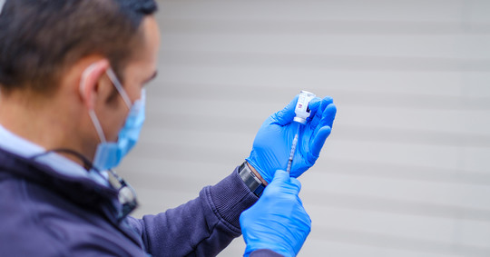 A Seattle Firefighter prepares a COVID-19 vaccine