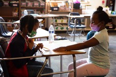 Students learning together in a classroom with masks on 