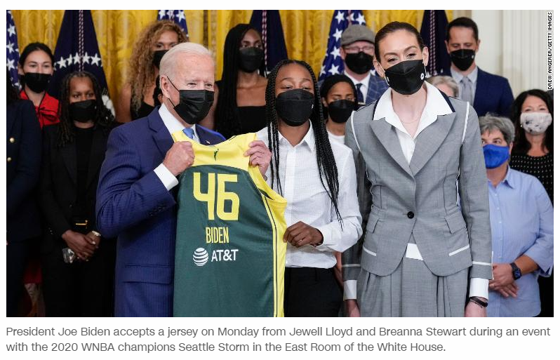 President Joe Biden accepts a jersey on Monday from Jewell Lloyd and Breanna Stewart in the East Room of the White House.