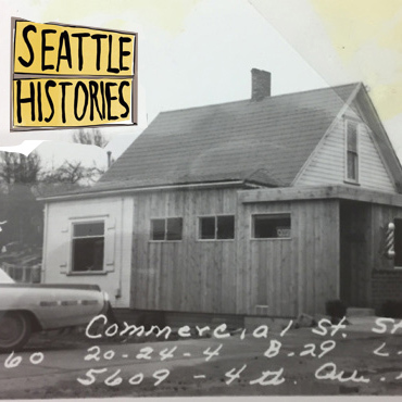 An historic black and white photo of a building with a yellow and black graphic in the corner that says "Seattle Histories"