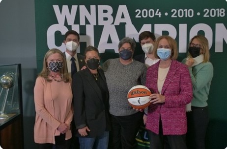 Mayor Durkan, with Seattle Storm leaders pose with a signed basketball