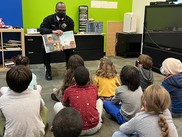 Chief Harold Scoggins reads Why Not You? to a group of children at a local Boys & Girls Club