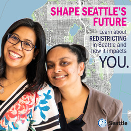 Two women standing close together, smiling with a map of Seattle in the background