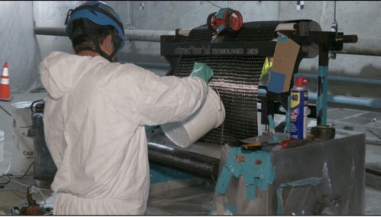 Pouring a bonding compound into the carbon-fiber press to strengthen the wrap. 