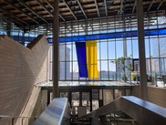 Interior of Seattle City Hall with a very large Ukrainian flag hanging from the walkway.