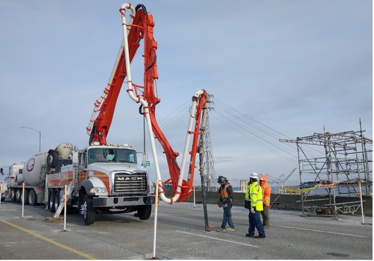 Concrete is pumped from the bridge deck into the inside of the bridge. 