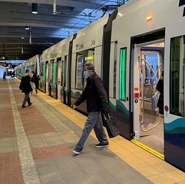 A person exiting a Sound Transit light rail in a tunnel station with brick floor